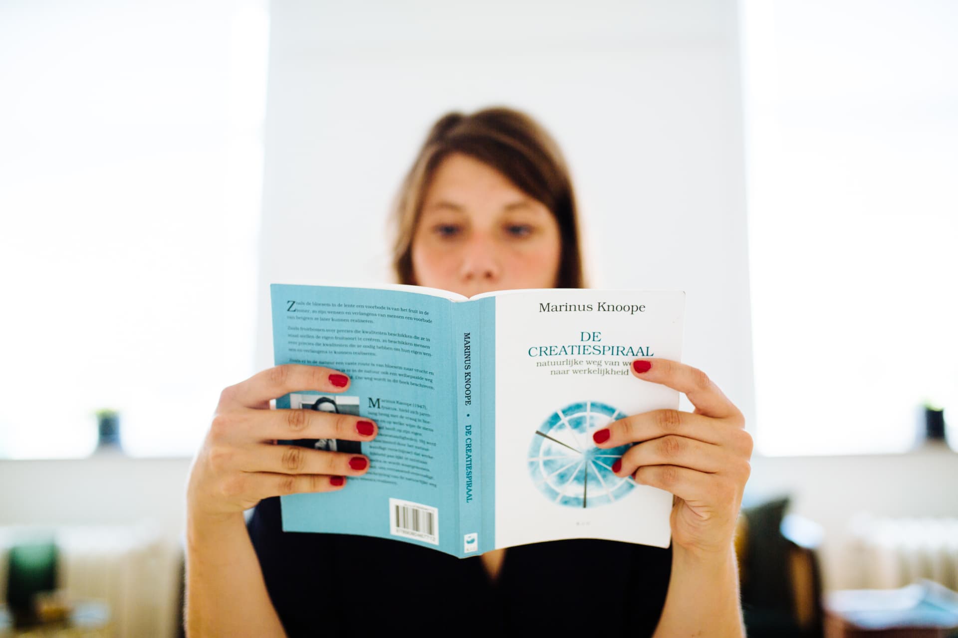 Tessa leest met een speelse blik uit een boek