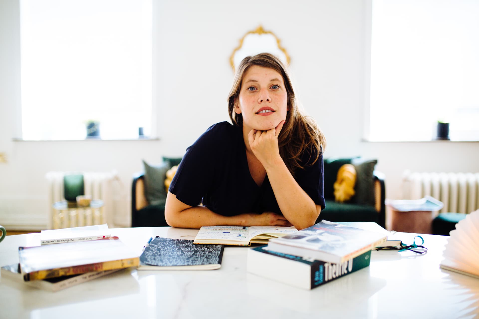 Tessa aan een tafel vol boeken en notities
