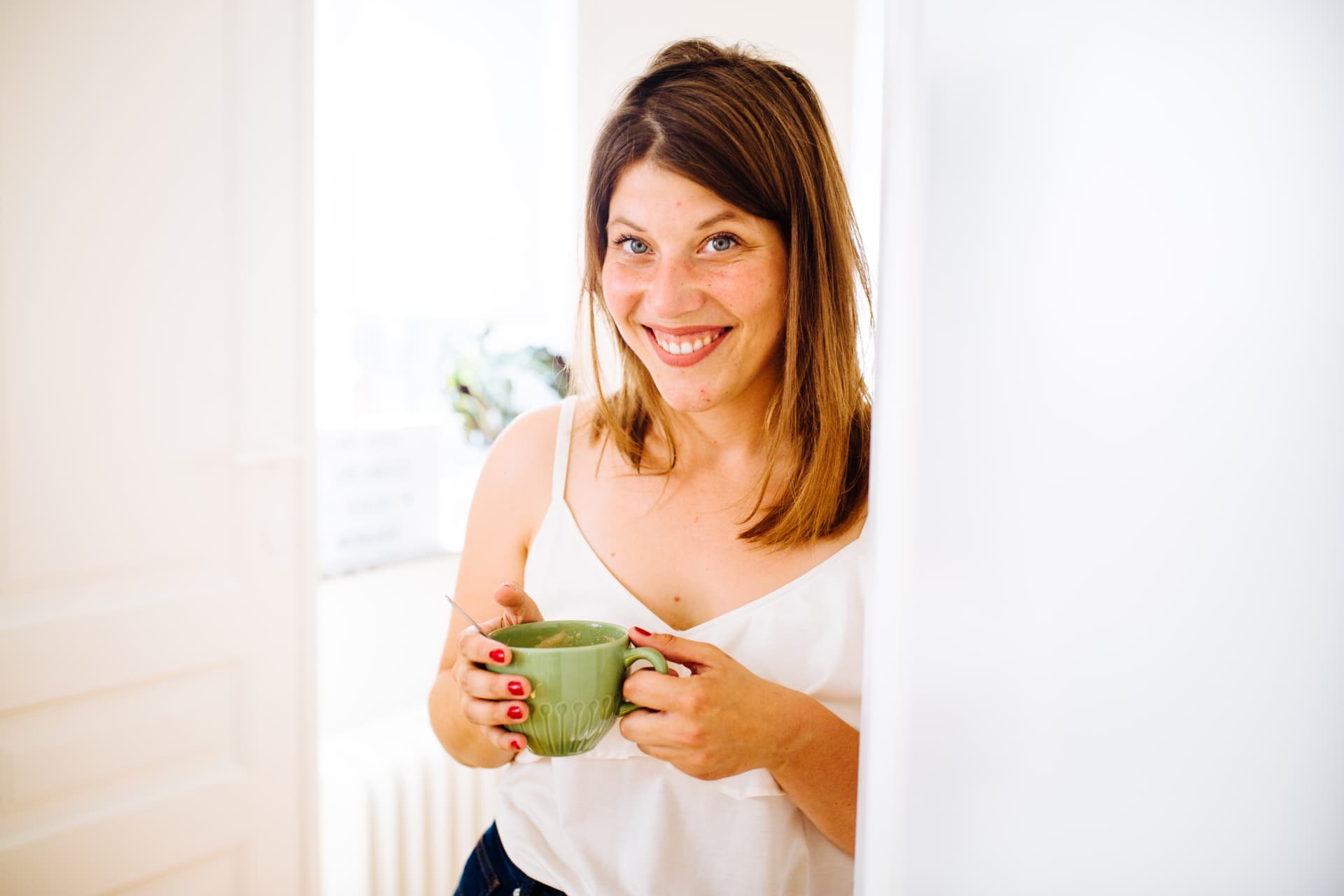 Tessa lachend met een groene tas thee